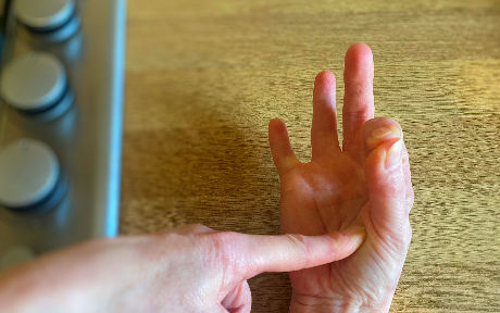 index finger touching thumb to show rare texture of a steak