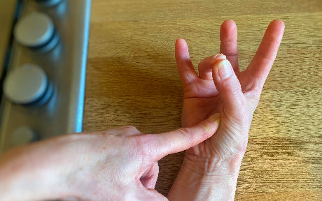 ring finger touching thumb to show medium well texture of a steak