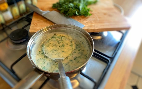 pan of parsley sauce with a ladle in