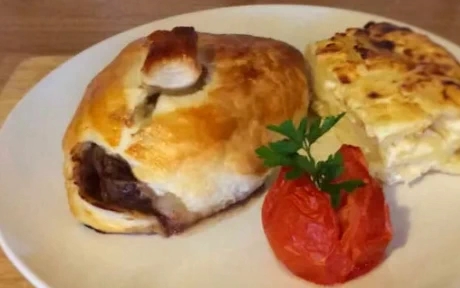 beef in a puff pastry case with tomato and potato