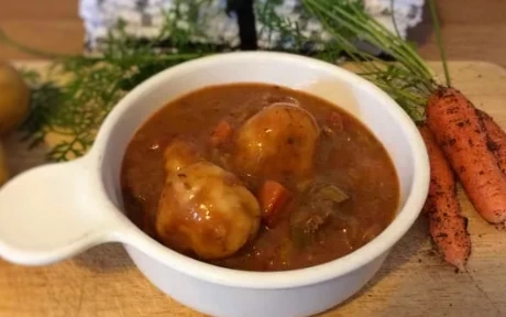 a bowl of beef stew with dumplings