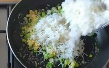 egg fried rice being made in a frying pan