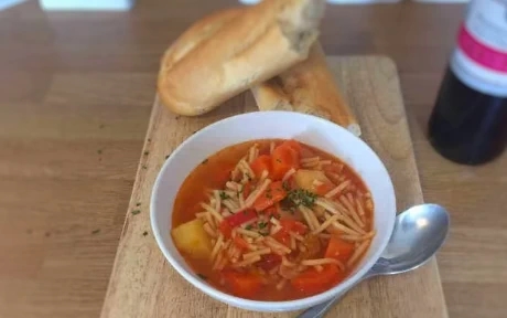 bowl of minestrone soup with french loaf bread
