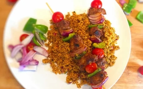 lamb skewers on a plate with couscous