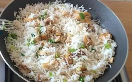 mushroom fried rice cooking in a frying pan