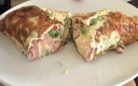 cut in half rolled omelette with ham and vegetables