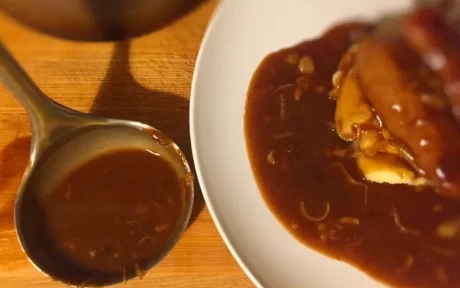 onion gravy in a ladle