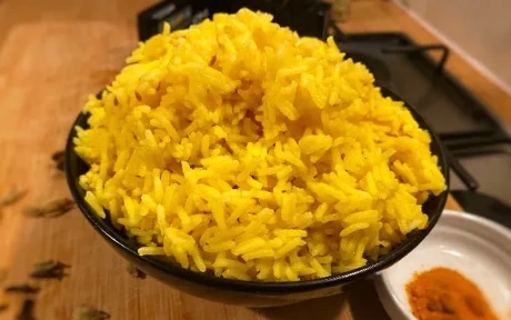 yello pilau rice in a black bowl