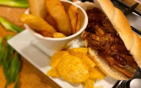 pulled pork in a roll with chips