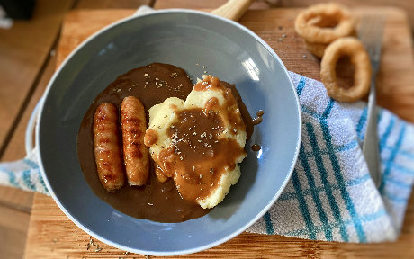 sausages and mashed potato on a plate with gravy
