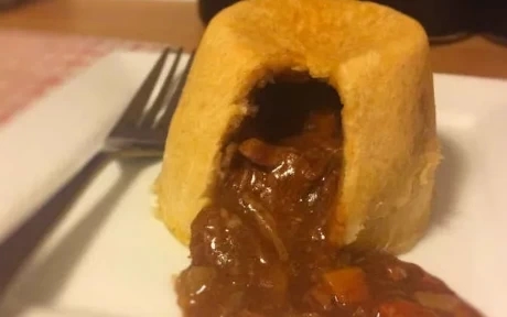cut open steak and vegetable pudding with gravy