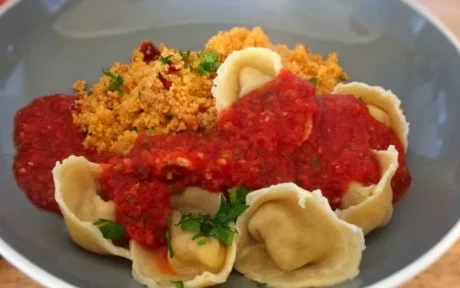 a bowl of tortellini with sauce