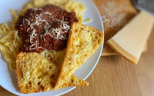 side of cheesy garlic bread with spaghetti bolognese